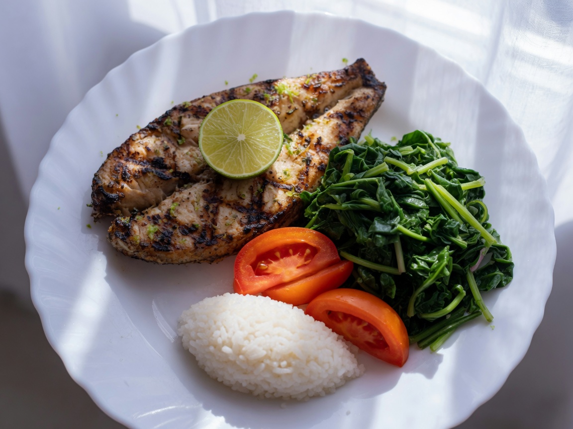 Plate of grilled fish, lots of greens, tomato, and a little rice